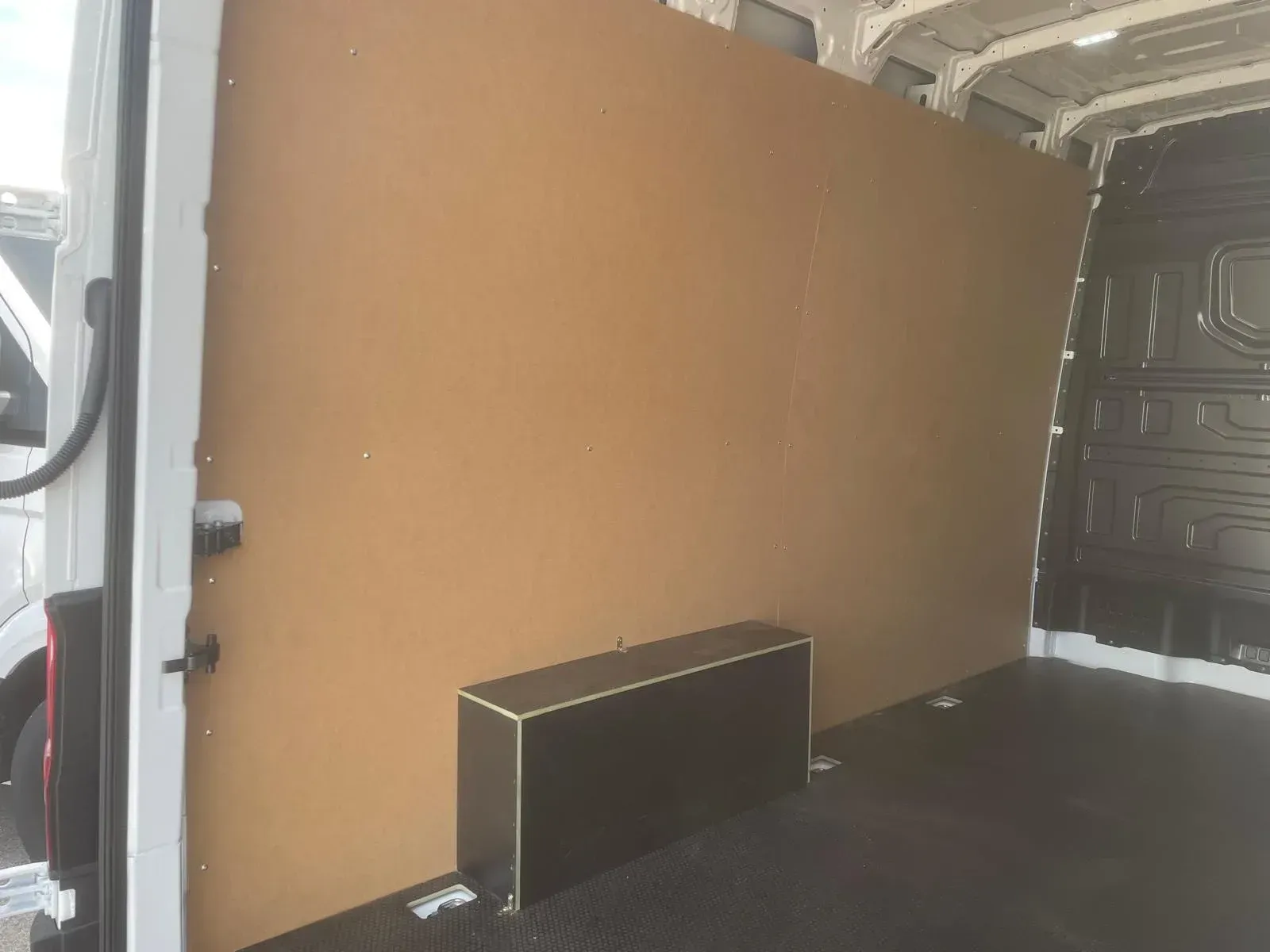 Interior de furgoneta protegido con paneles de madera, suelo técnico y revestimiento del paso de rueda